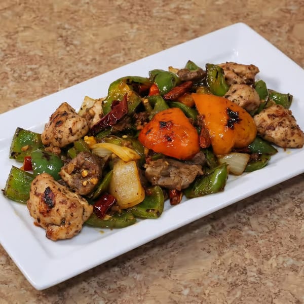 Spicy chicken and beef stir-fry with green and orange bell peppers, onions, and dried chilies.