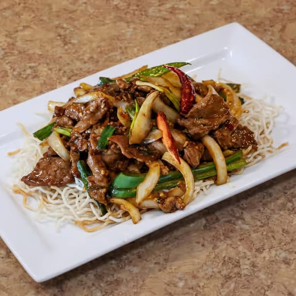 Stir-fried beef with onions, green peppers, and chili on a bed of crispy noodles.